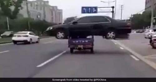 Man transports abandoned car with three-wheeler in China  